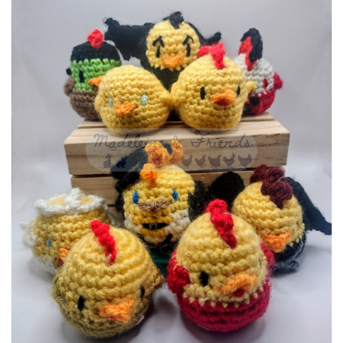 A gethering of small crochet chickens in various styles. some have extra angel or demon wings, some have different coloured bodies as if they are wearing clothes, one looks like a chicken Frankenstein's monster, and another is wearing a little black hat.