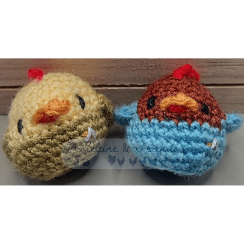 Two small crochet chickens in Star Trek Starfleet uniforms. On the left, a yellow chicken in a gold uniform. On the right, a brown chicken in a blue uniform.