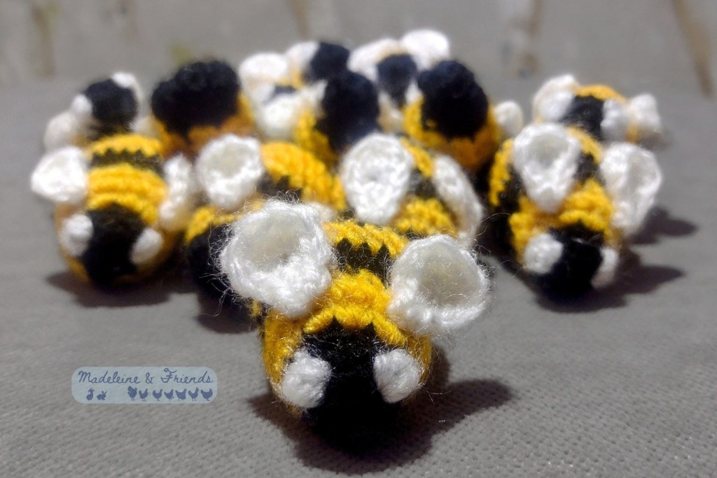 A mass of tiny crochet bees in a V formation, all facing forward.